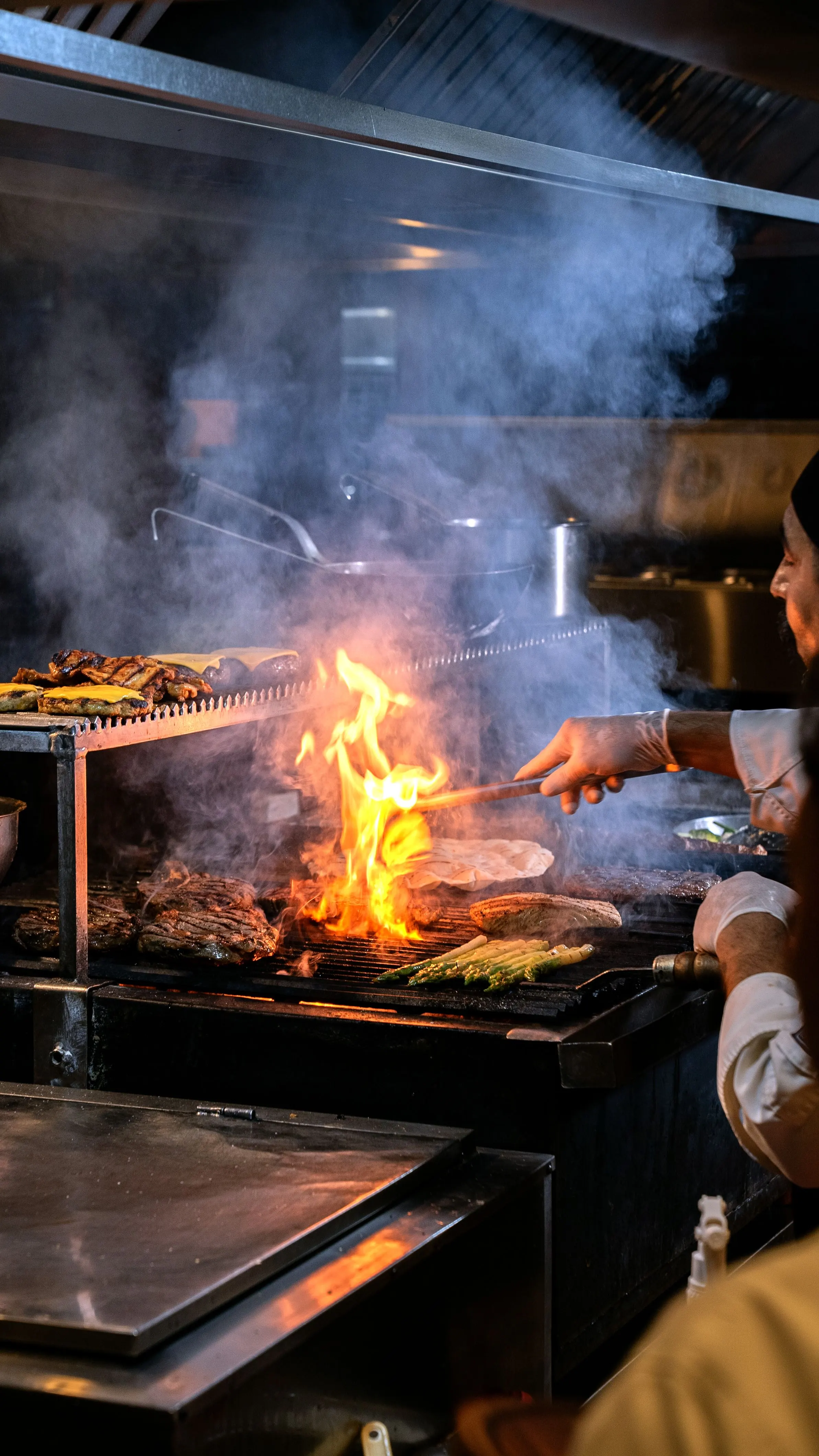 Llamas y brasas vivas en la parrilla de leña de la cocina de Asador Artebe